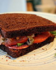 Сендвич из ржаного хлеба с салями и помидором