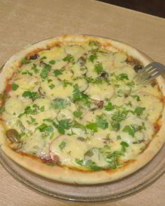 Итальянская тонкая пицца с ветчиной сыром и грибами